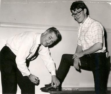 20世纪60年代初，福斯特校长在家长日活动期间为一名学生擦鞋.